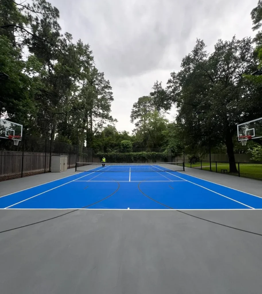 Blue and gray custom backyard court featuring tennis and full-court basketball layout