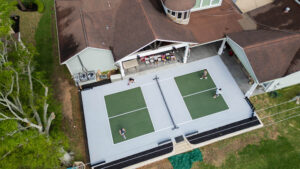 Green and gray family pickleball court near a clubhouse — stylish and fun setup for community or backyard play.