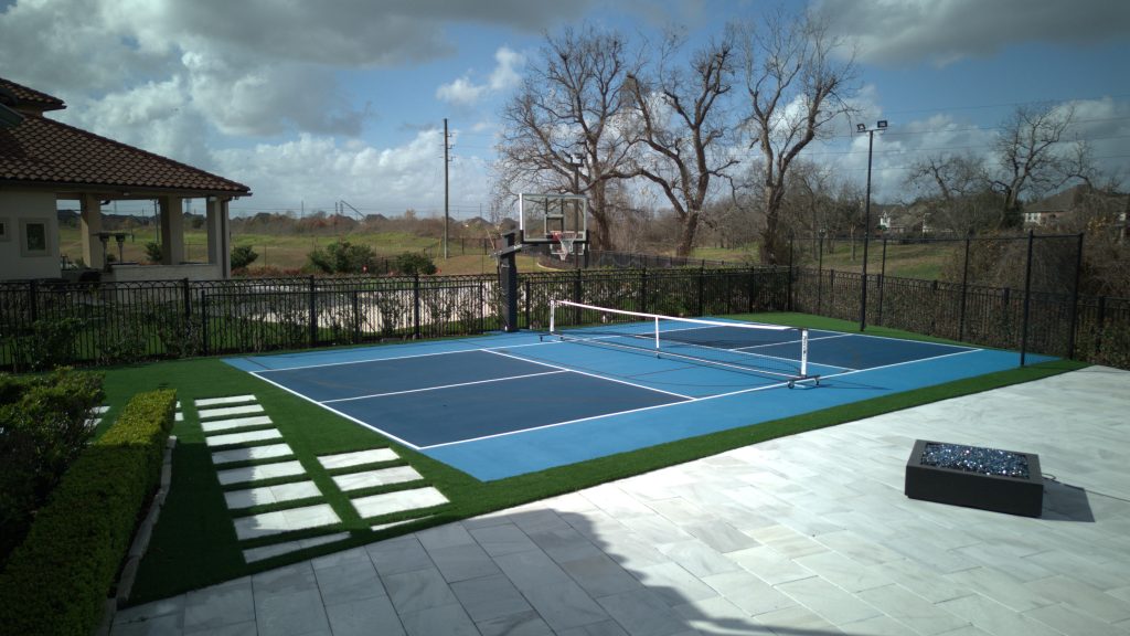 A residential pickleball court in Riverstone, Texas, featuring vibrant blue tones and a smooth, high-quality playing surface.