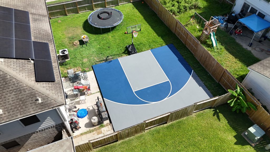Mini basketball court in Bayton, TX with blue and grey surfacing, painted lines, and a pro-grade hoop on a 25x30 concrete pad.