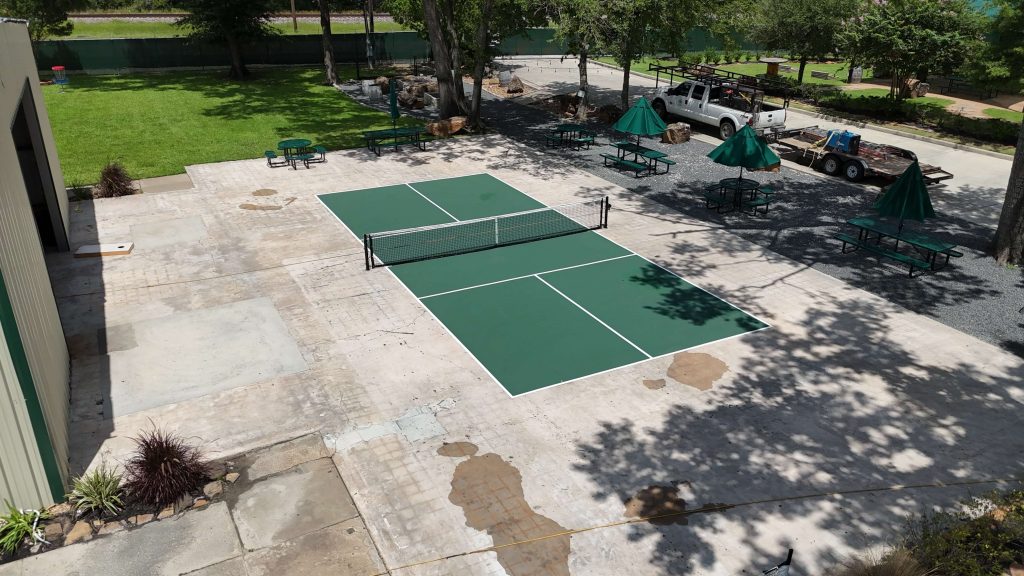 “Pickleball court surfacing in Houston at Spindletap Brewery with green surface, white lines, and in-ground net