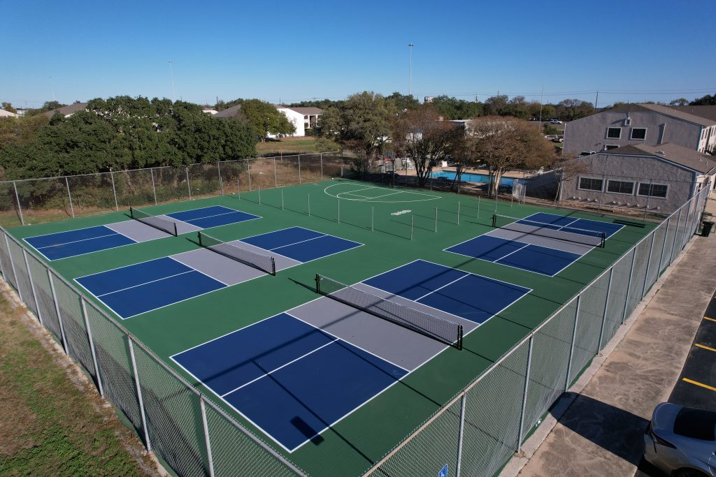 Completed tennis court resurfacing showing four side-by-side pickleball courts ready for play