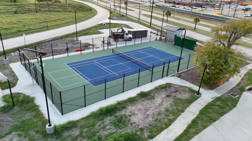 Tennis court showing surface cracks and fading lines ready for professional resurfacing in Texas