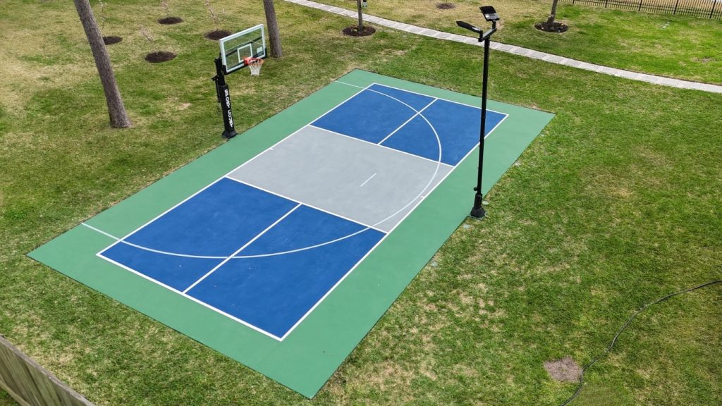 Residential backyard pickleball court construction with basketball hoop in League City Texas